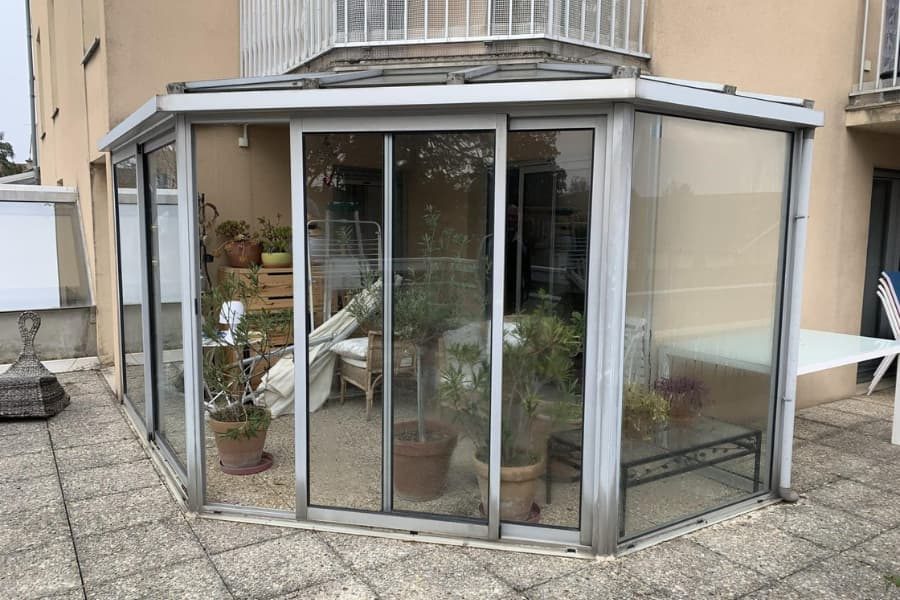 Véranda en aluminium et verre accolée à une maison