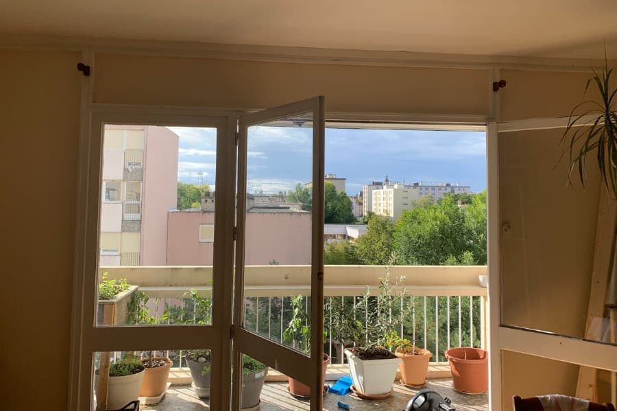 Porte-fenêtre en bois ouvrant sur un balcon