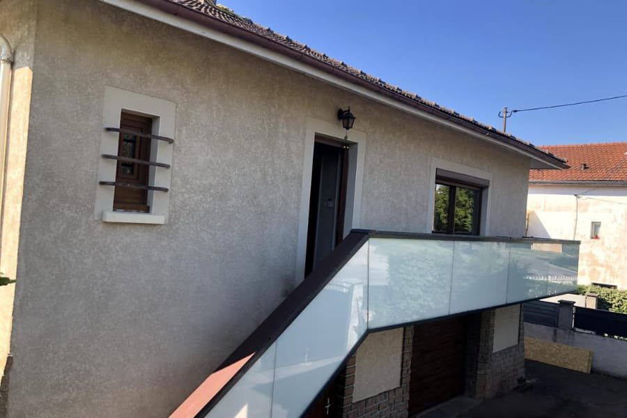 Terrasse de maison bordée d'un garde-corps vitré