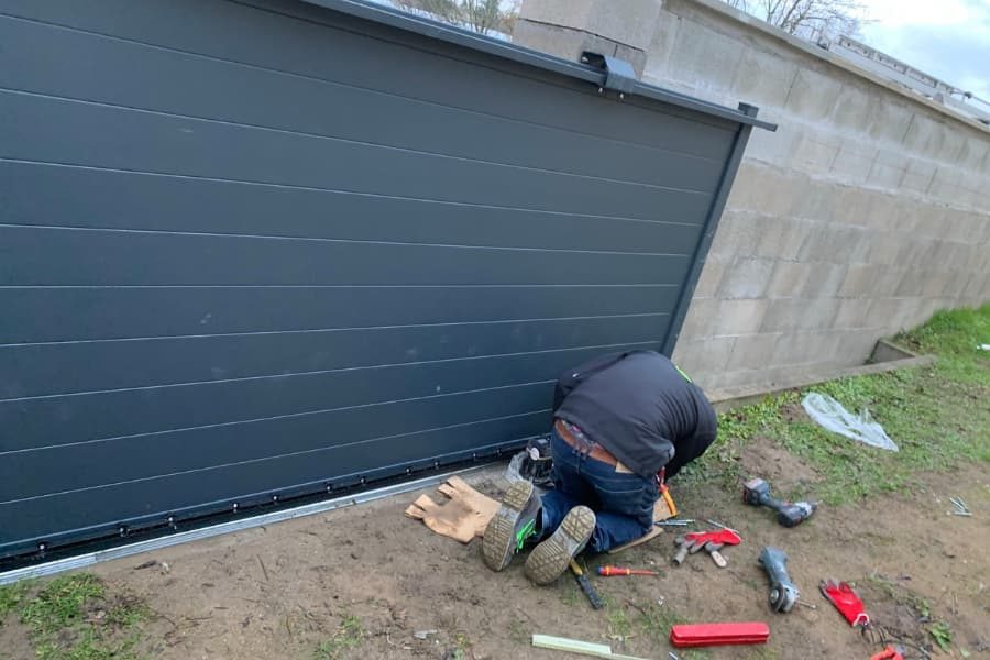 Artisan posant une porte de garage sectionnelle