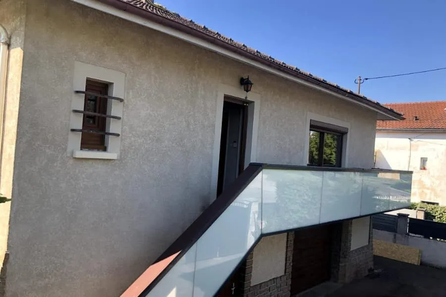 Terrasse de maison bordée d'un garde-corps vitré